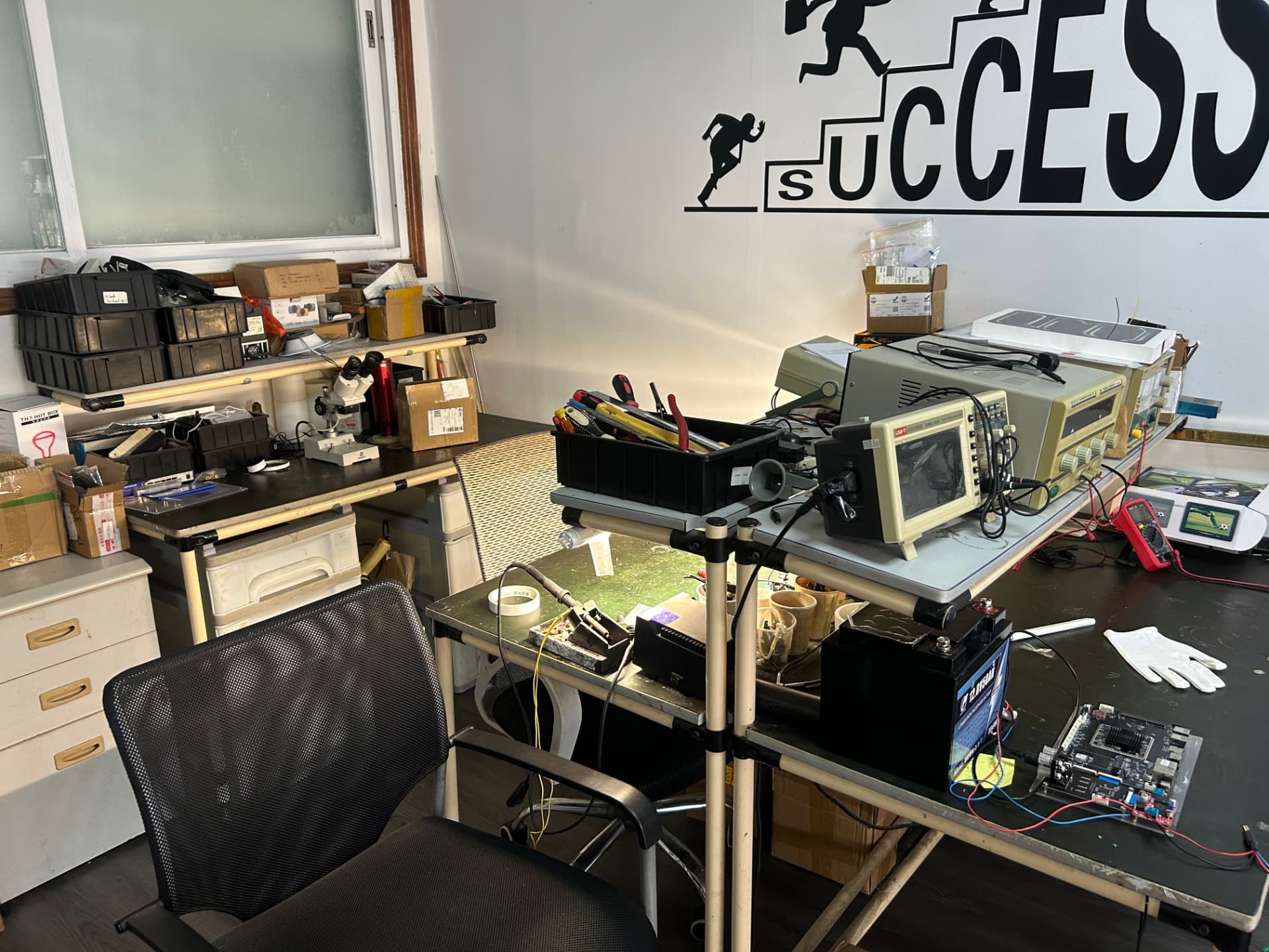 Electronics testing bench with oscilloscope, power supply and microscope
